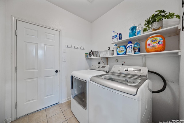 clothes washing area featuring washing machine and dryer and light tile patterned floors