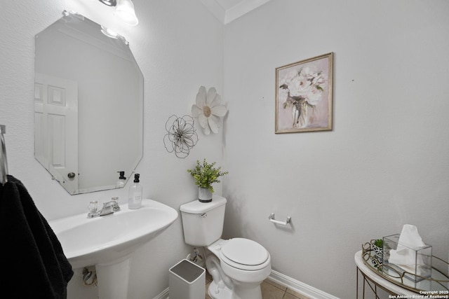 half bathroom with toilet, a sink, tile patterned flooring, and baseboards