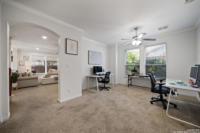 carpeted office space featuring arched walkways, ceiling fan, crown molding, healthy amount of natural light, and baseboards