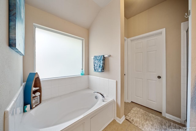 bathroom with a bath, tile patterned flooring, and baseboards