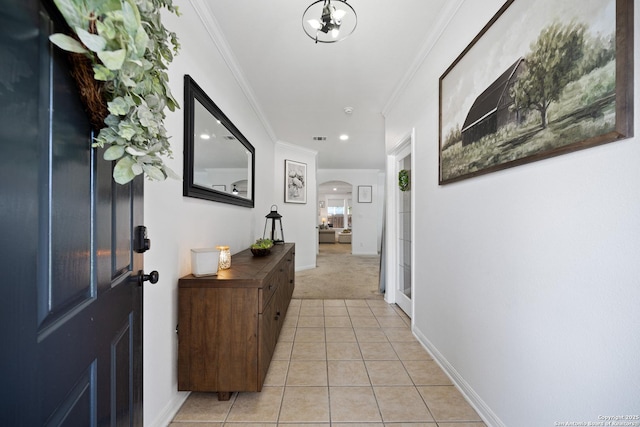 entryway featuring arched walkways, light tile patterned floors, light colored carpet, ornamental molding, and recessed lighting