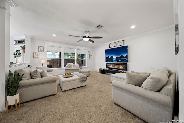 carpeted living room with ornamental molding, ceiling fan, a glass covered fireplace, recessed lighting, and ornate columns