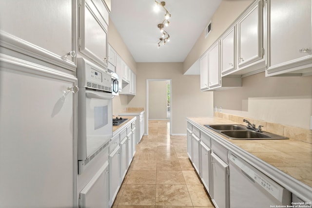 3678 Hidden Unit 504, San Antonio, TX 78217 - kitchen featuring white appliances, a sink, white cabinets, and tile countertops