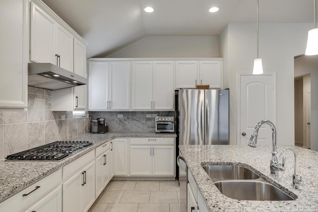 12243 Dusty Boots, San Antonio, TX 78254 - kitchen featuring under cabinet range hood, appliances with stainless steel finishes, vaulted ceiling, white cabinets, and tasteful backsplash