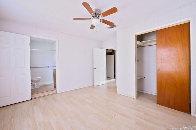 unfurnished bedroom with wood finished floors, ensuite bath, a closet, ceiling fan, and baseboards