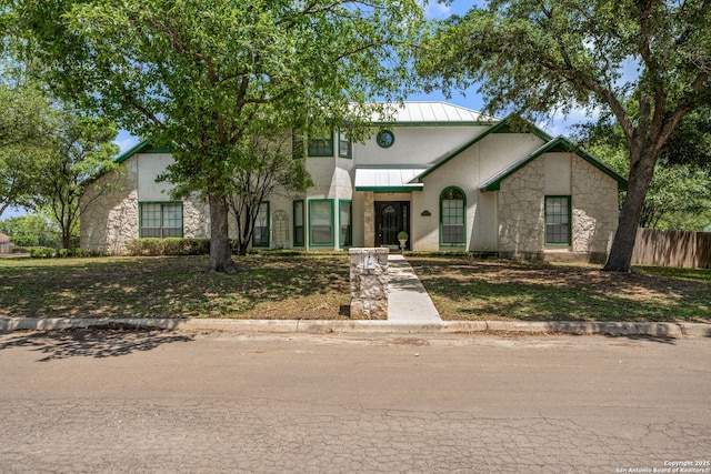 107 River Knl, Castroville, TX 78009 - view of front of home featuring stone siding, fence, stucco siding, and metal roof