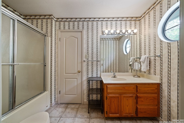 107 River Knl, Castroville, TX 78009 - full bathroom with wallpapered walls, plenty of natural light, vanity, bath / shower combo with glass door, and toilet