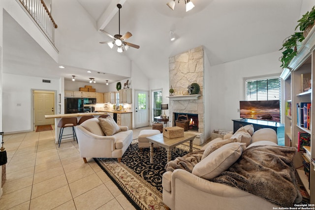 107 River Knl, Castroville, TX 78009 - living room featuring a ceiling fan, high vaulted ceiling, a stone fireplace, light tile patterned floors, and plenty of natural light