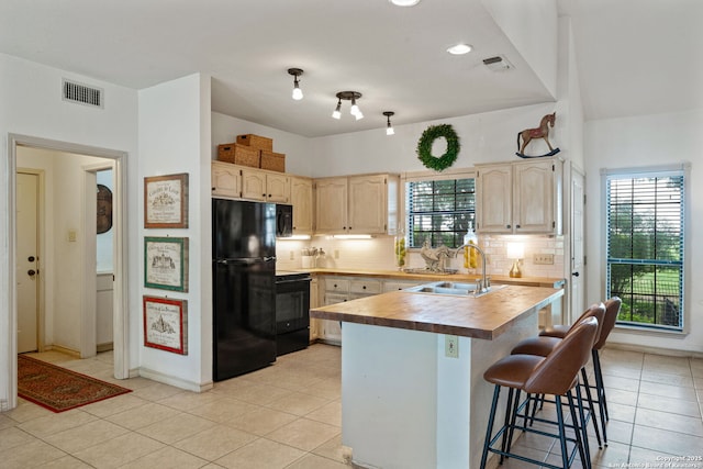 107 River Knl, Castroville, TX 78009 - kitchen with black appliances, a sink, light brown cabinetry, tasteful backsplash, and a breakfast bar area