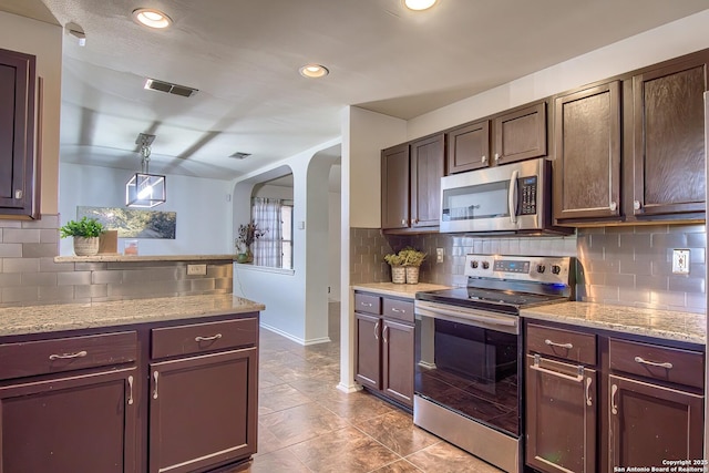 kitchen featuring stainless steel appliances, tasteful backsplash, arched walkways, dark brown cabinetry, and recessed lighting