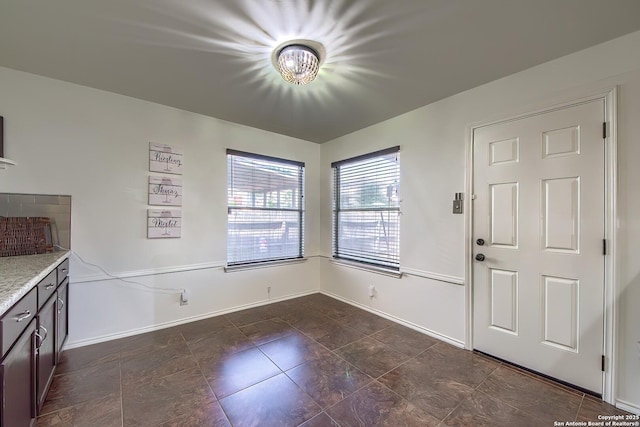 unfurnished dining area with baseboards