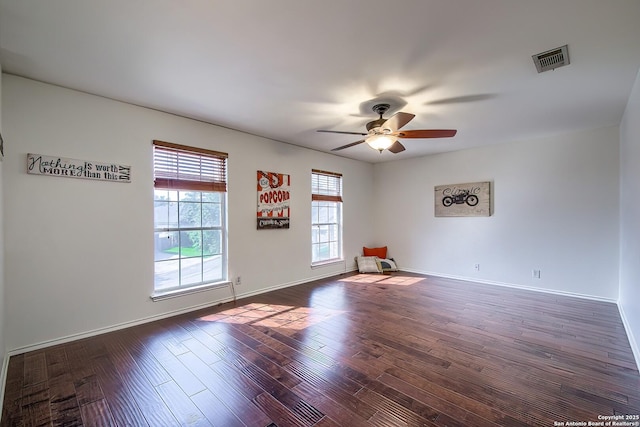 unfurnished room featuring a ceiling fan, dark wood finished floors, and baseboards