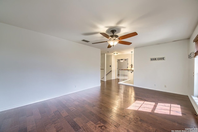 unfurnished room featuring a ceiling fan, dark wood-style floors, and baseboards