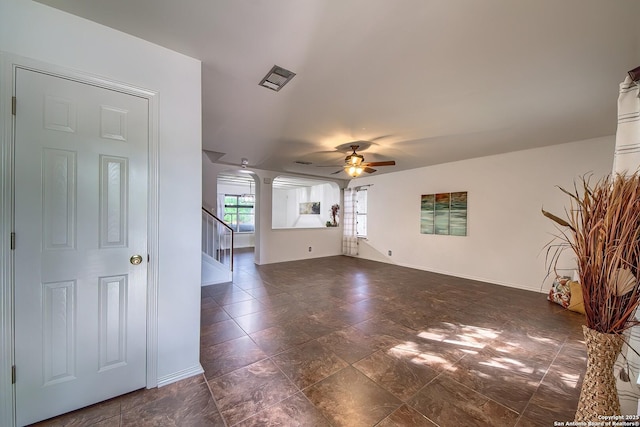 unfurnished living room featuring ceiling fan, stairs, and baseboards