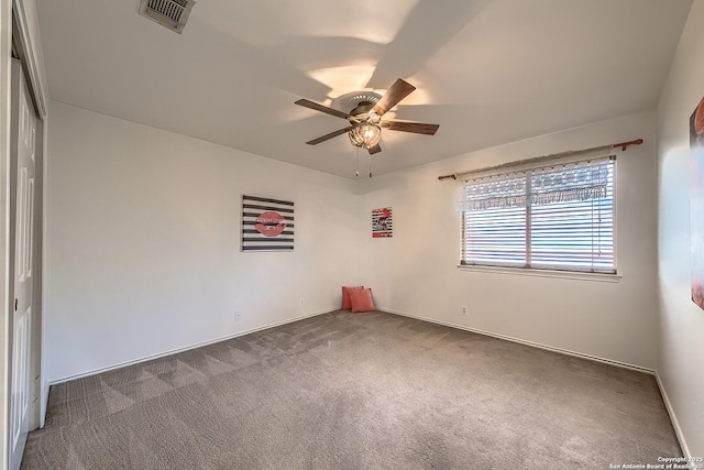 carpeted empty room featuring ceiling fan and baseboards