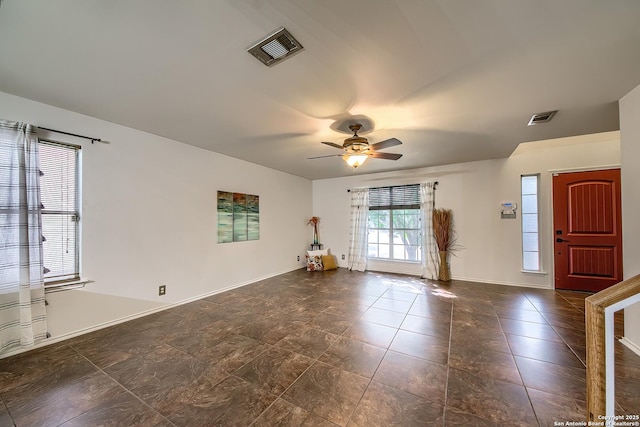 unfurnished room with ceiling fan and baseboards