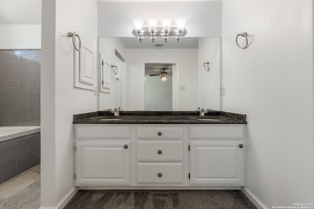 107 Mesa Del Sol, Kerrville, TX 78028 - bathroom featuring double vanity, tiled tub, baseboards, a ceiling fan, and a chandelier