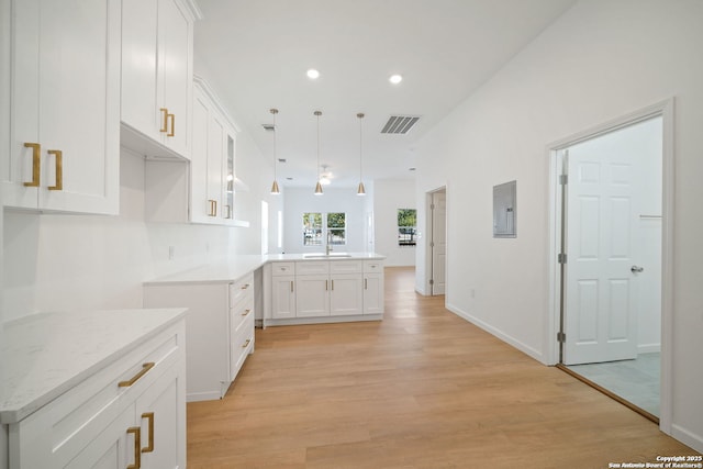 1212 Morales, San Antonio, TX 78207 - kitchen with a peninsula, light wood-style floors, white cabinetry, a sink, and recessed lighting