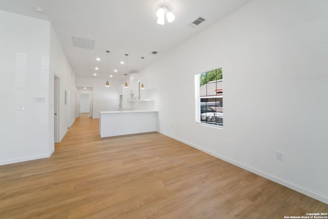 1212 Morales, San Antonio, TX 78207 - unfurnished living room with light wood-type flooring, baseboards, and recessed lighting
