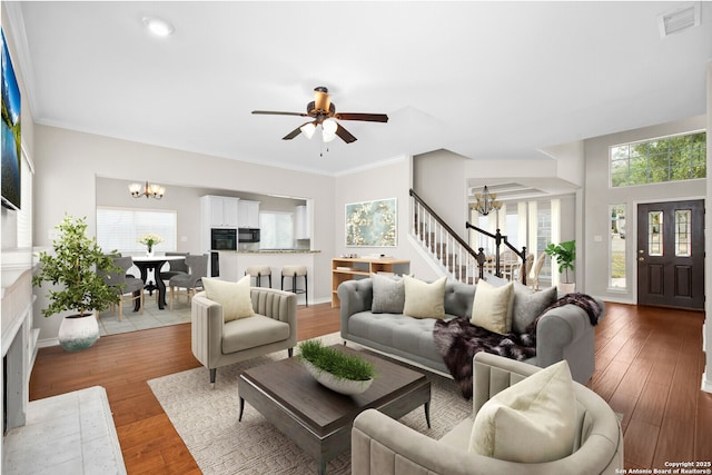 18127 Brookwood Frst, San Antonio, TX 78258 - living room featuring a chandelier, wood finished floors, a ceiling fan, and stairway