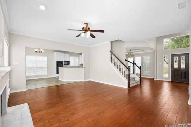18127 Brookwood Frst, San Antonio, TX 78258 - unfurnished living room featuring a chandelier, stairway, and wood finished floors