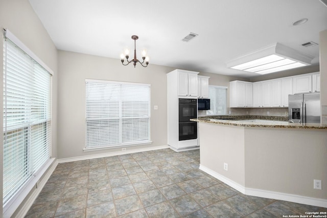 18127 Brookwood Frst, San Antonio, TX 78258 - kitchen with black appliances, a chandelier, stone countertops, white cabinetry, and baseboards