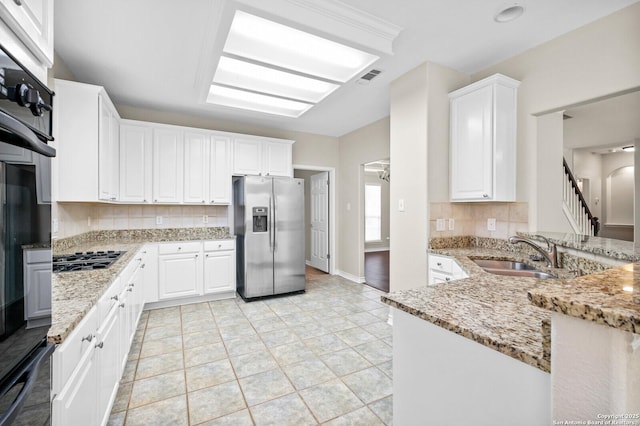 18127 Brookwood Frst, San Antonio, TX 78258 - kitchen with stainless steel fridge with ice dispenser, a sink, backsplash, gas stovetop, and light stone countertops