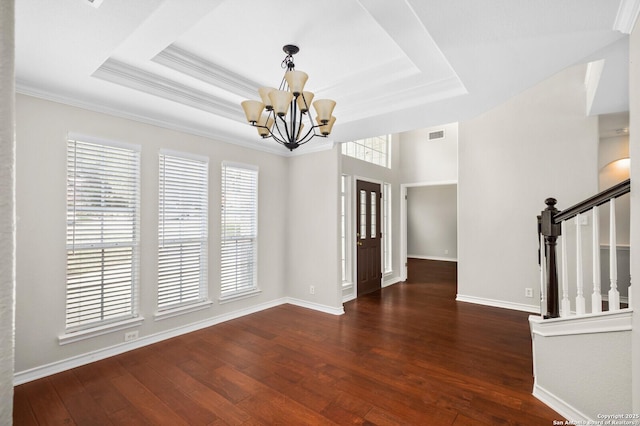 18127 Brookwood Frst, San Antonio, TX 78258 - unfurnished dining area with a chandelier, wood-type flooring, a tray ceiling, stairs, and baseboards
