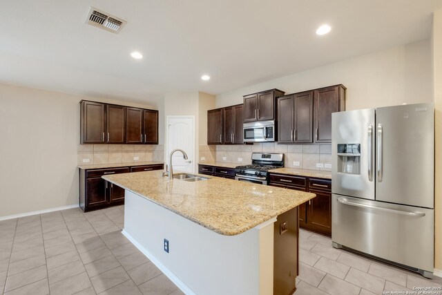 173 Kildeer Crk, San Antonio, TX 78253 - kitchen featuring stainless steel appliances, a sink, dark brown cabinets, light tile patterned floors, and an island with sink