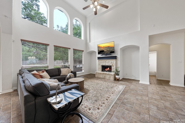 1326 Walkers Way, San Antonio, TX 78216 - living area with a towering ceiling, ceiling fan, stone finish flooring, baseboards, and a stone fireplace