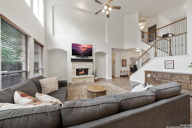 1326 Walkers Way, San Antonio, TX 78216 - living room with a high ceiling, a ceiling fan, stairs, a stone fireplace, and baseboards