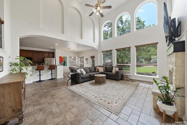 1326 Walkers Way, San Antonio, TX 78216 - living room featuring a high ceiling, a ceiling fan, stone tile flooring, arched walkways, and healthy amount of natural light