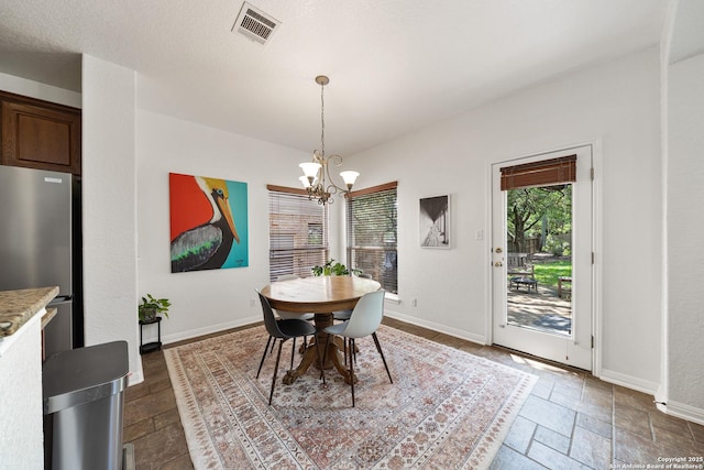 1326 Walkers Way, San Antonio, TX 78216 - dining space featuring a chandelier, stone tile floors, and baseboards