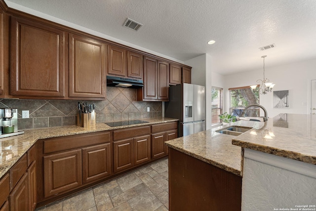 1326 Walkers Way, San Antonio, TX 78216 - kitchen with stainless steel fridge, a sink, under cabinet range hood, backsplash, and hanging light fixtures