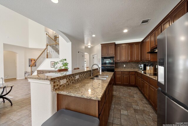 1326 Walkers Way, San Antonio, TX 78216 - kitchen featuring black appliances, arched walkways, tasteful backsplash, a sink, and light stone counters