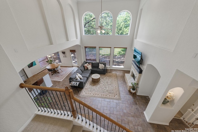 1326 Walkers Way, San Antonio, TX 78216 - living room with a towering ceiling, ceiling fan, a fireplace, stairway, and baseboards