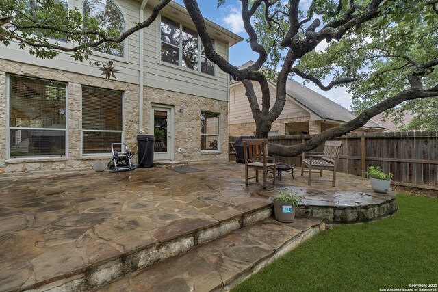 1326 Walkers Way, San Antonio, TX 78216 - back of house with a patio, fence, and stone siding