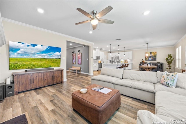 11334 Hill Top Bnd, Helotes, TX 78023 - living room with ornamental molding, ceiling fan, light wood-type flooring, recessed lighting, and baseboards