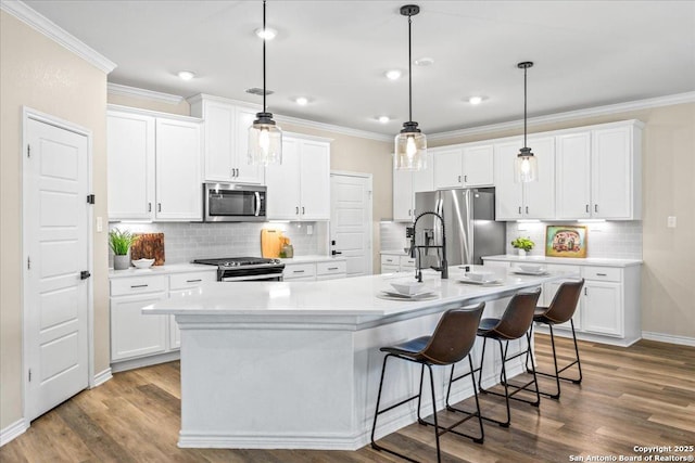 11334 Hill Top Bnd, Helotes, TX 78023 - kitchen with appliances with stainless steel finishes, crown molding, a kitchen island with sink, white cabinets, and backsplash