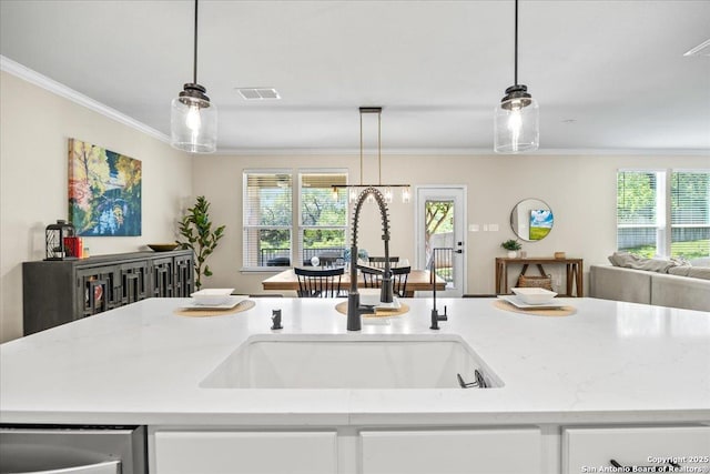 11334 Hill Top Bnd, Helotes, TX 78023 - kitchen with a sink, open floor plan, ornamental molding, decorative light fixtures, and light stone counters