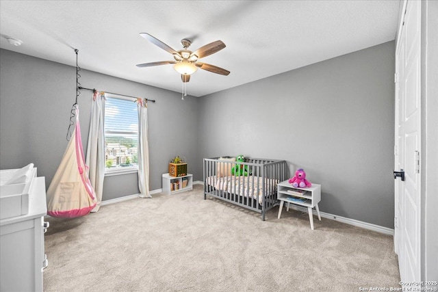 11334 Hill Top Bnd, Helotes, TX 78023 - carpeted bedroom with baseboards, a nursery area, and ceiling fan