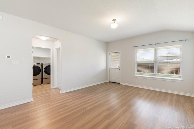 9525 Moon Shine, San Antonio, TX 78254 - unfurnished room featuring arched walkways, washer and clothes dryer, light wood-style floors, baseboards, and lofted ceiling