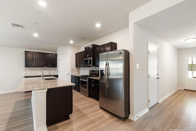 9525 Moon Shine, San Antonio, TX 78254 - kitchen featuring stainless steel appliances, a sink, light wood-style flooring, tasteful backsplash, and baseboards