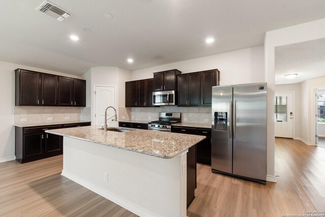 9525 Moon Shine, San Antonio, TX 78254 - kitchen featuring stainless steel appliances, a sink, light wood-style flooring, decorative backsplash, and recessed lighting
