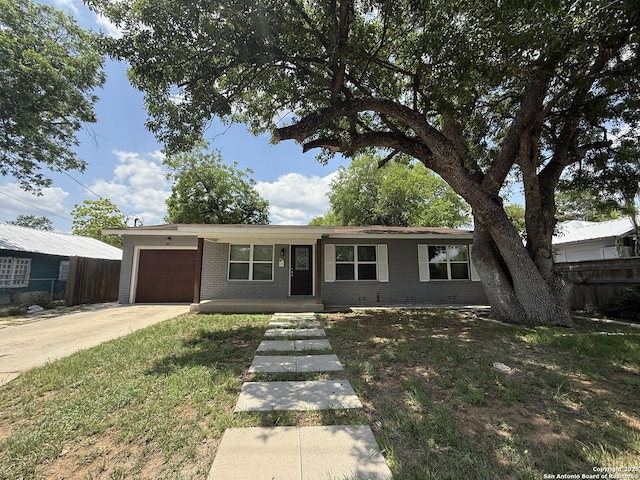 single story home featuring a garage, brick siding, and driveway