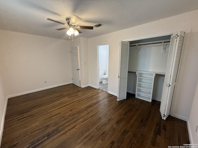 unfurnished bedroom featuring dark wood-style floors, baseboards, and a closet
