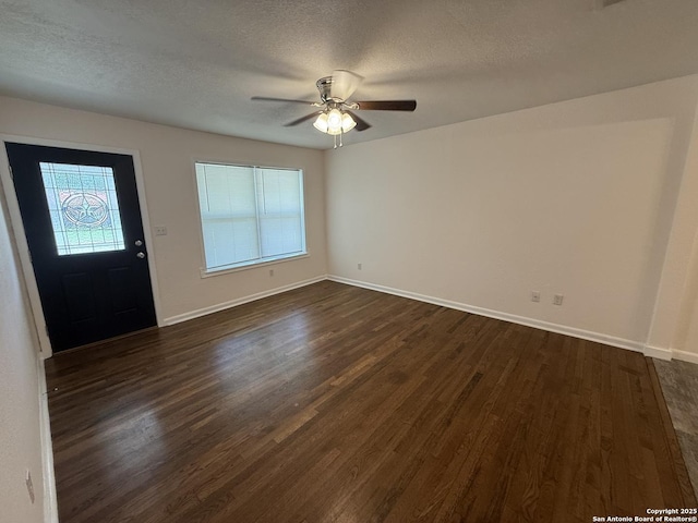 entryway featuring dark wood-type flooring, a textured ceiling, baseboards, and ceiling fan
