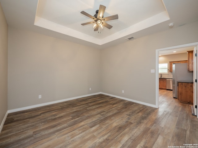 182 Inwood, Poteet, TX 78065 - spare room with a raised ceiling, a ceiling fan, dark wood-style floors, baseboards, and a smoke detector