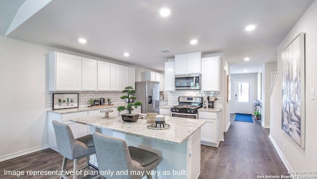 kitchen featuring appliances with stainless steel finishes, decorative backsplash, white cabinets, dark wood-type flooring, and recessed lighting