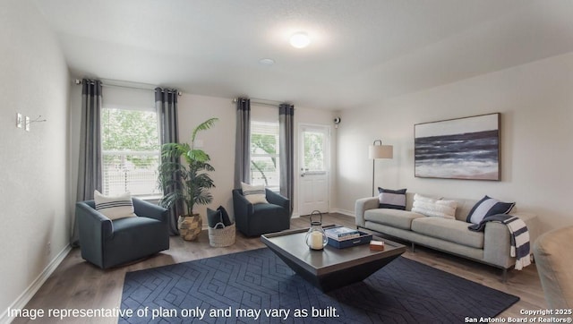 living area featuring wood finished floors, healthy amount of natural light, and baseboards